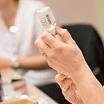 Female pulling medicine out of a vial into a syringe.